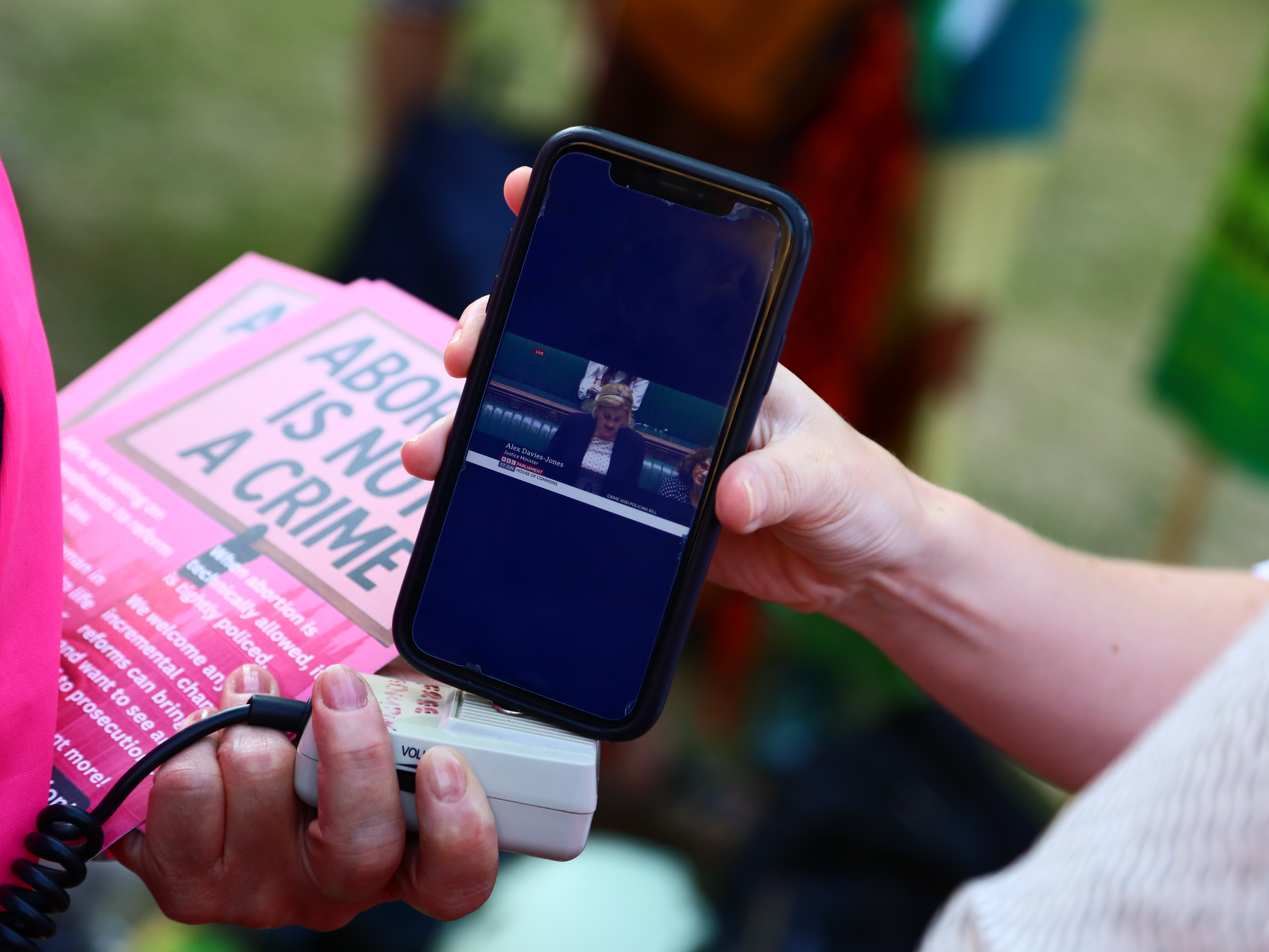 caption: Protesters from 'Abortion Rights' watch Alex Davies-Jones, Parliamentary under-secretary of state at the Ministry of Justice, talk in the House of Commons as they gather near Parliament, where MPs are voting on the decriminalization of abortion on June 17 in London.