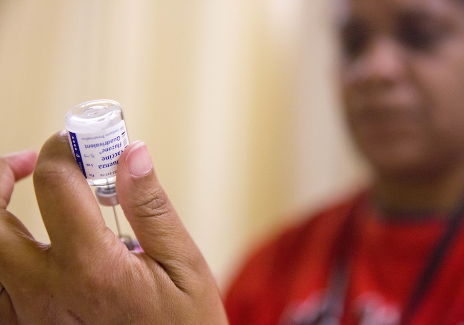 caption: FILE - In this Wednesday, Feb. 7, 2018 file photo, a nurse prepares a flu shot from a vaccine vial at the Salvation Army in Atlanta. 
