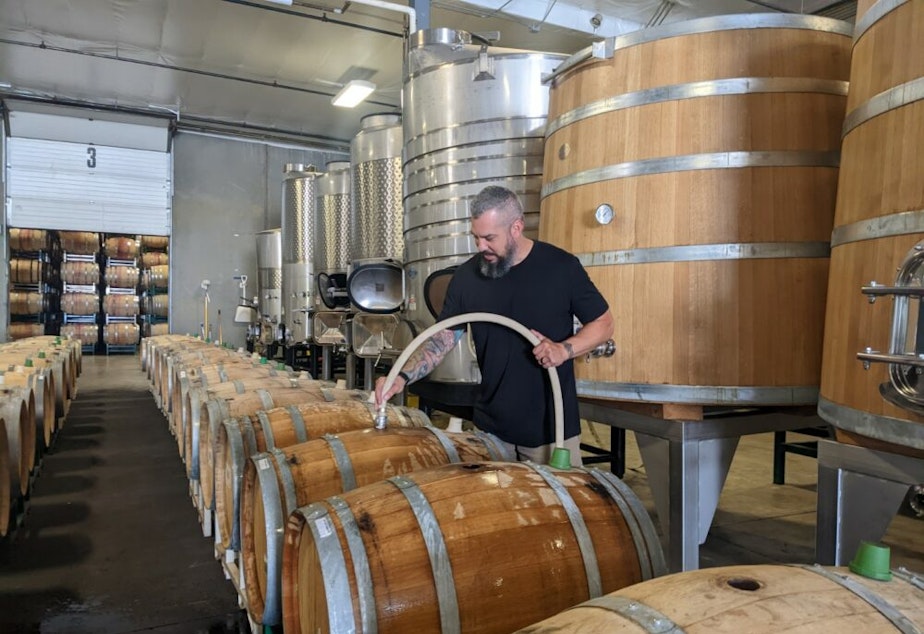caption: Winemaker Mitch Venohr soaks some wooden wine barrels to prepare them for wine. Barrels are hydrated to tighten the wood and prevent leaking.