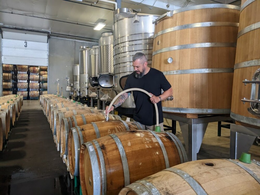caption: Winemaker Mitch Venohr soaks some wooden wine barrels to prepare them for wine. Barrels are hydrated to tighten the wood and prevent leaking.