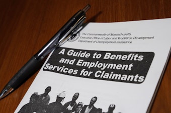 caption: A booklet describing unemployment benefits is seen on a desk in North Andover, MA. (Elise Amendola/AP)
