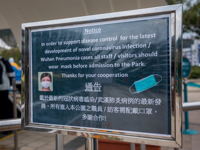 caption: A notice advising all staff and visitors to wear protective masks stands outside the closed Ocean Park in Hong Kong, on Monday.