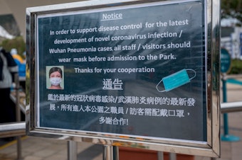 caption: A notice advising all staff and visitors to wear protective masks stands outside the closed Ocean Park in Hong Kong, on Monday.