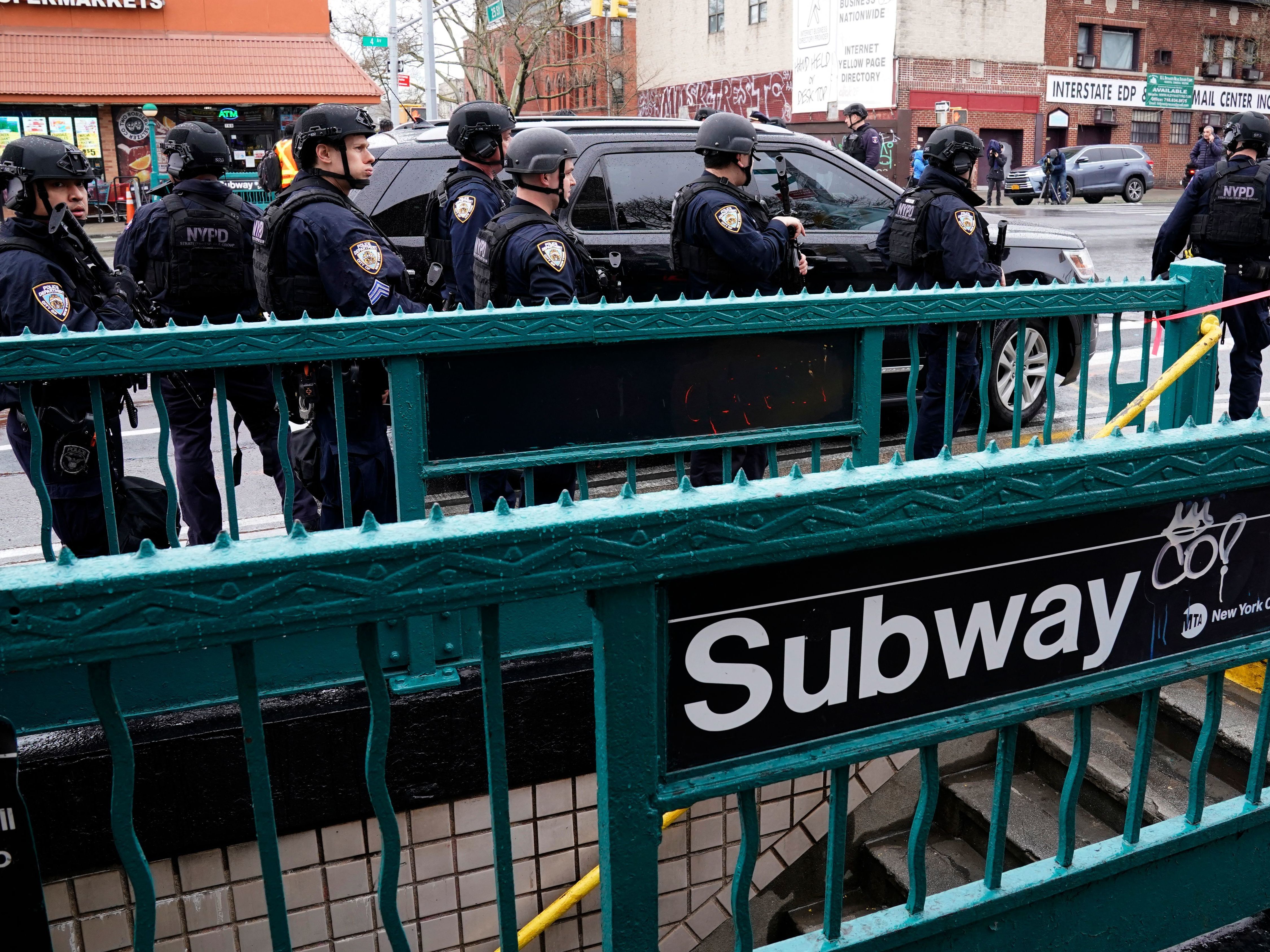 caption: Members of the New York Police Department patrol the streets after a rush-hour shooting at a subway station in Brooklyn on April 12.