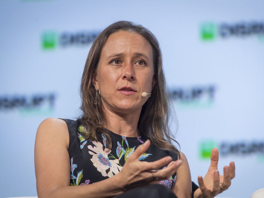 caption: Anne Wojcicki, chief executive officer and co-founder of 23andMe, speaks during the TechCrunch Disrupt 2018 summit in San Francisco in September 2018.