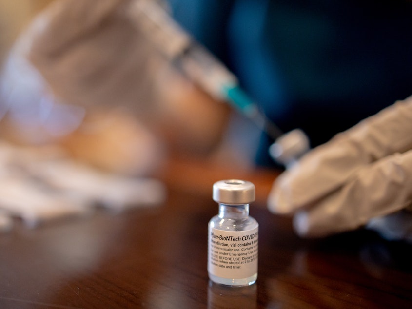 caption: A health care worker prepares Pfizer-BioNTech Covid-19 vaccines for third doses at a senior living facility in Worcester, Penn., in late August.