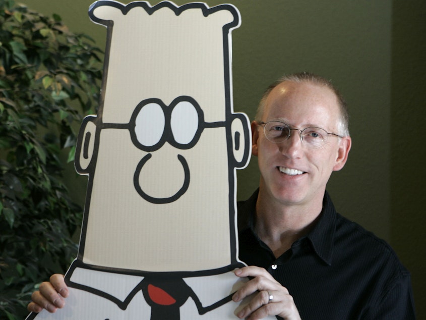 caption: Scott Adams, creator of the comic strip "Dilbert," poses for a portrait with the Dilbert character in his studio in Dublin, Calif., in 2006. Several prominent media publishers across the U.S. are dropping the comic strip after Adams described people who are Black as members of "a racist hate group" during an online video show.
