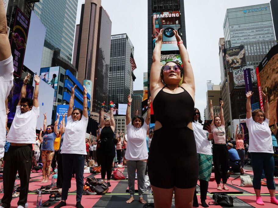 caption: People participate in a mass yoga session on International Yoga Day in Times Square on June 21, 2023 in New York City. The CDC finds about 1 in 6 adults in the U.S. practice yoga.