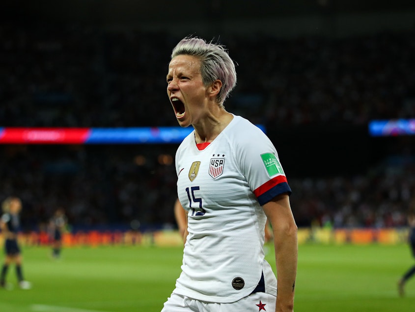 caption: U.S. forward Megan Rapinoe celebrates after scoring her team's second goal during Friday's quarterfinal match against France. The Americans now face an England squad that brings confidence and defensive power.