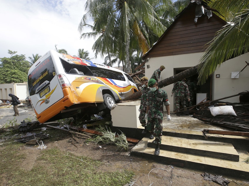 caption: Indonesian soldiers search for the bodies of tsunami victims at a beach resort on the island of Java on Monday. Waves swept terrified people into the sea Saturday night following an eruption on Anak Krakatau, one of the world's most infamous volcanic islands.