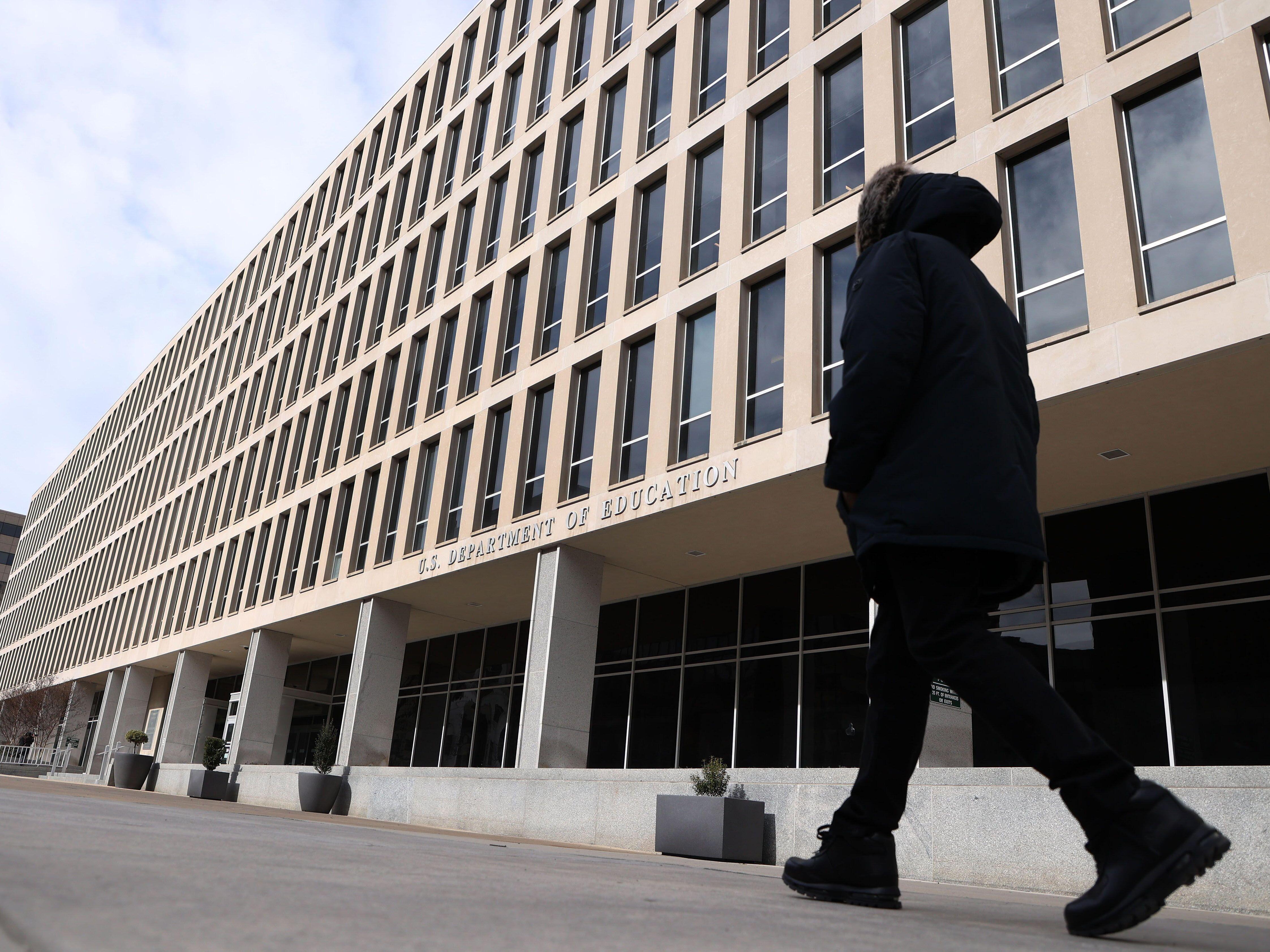 caption: A man walks past the U.S. Department of Education building in Washington, D.C., on Feb. 7.