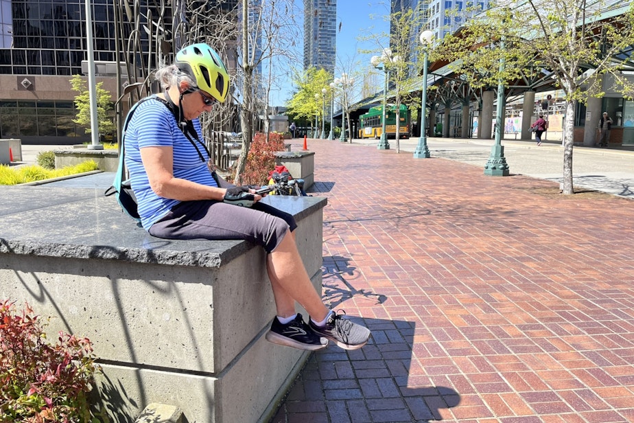 caption: Lil Hinett gets in some reading as she waits for a bus in Bellevue.