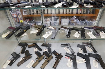 caption: The FBI has reported a surge in background checks for gun sales. Here, firearms are for sale at a shop in New Castle, Pa.