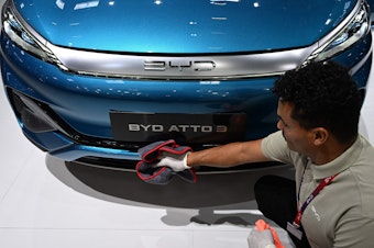 caption: A man polishes an Atto 3 car from Chinese car maker BYD at the International Motor Show (IAA) in Munich, Germany, on Sept. 4, 2023. The car has gained in popularity among Europeans.