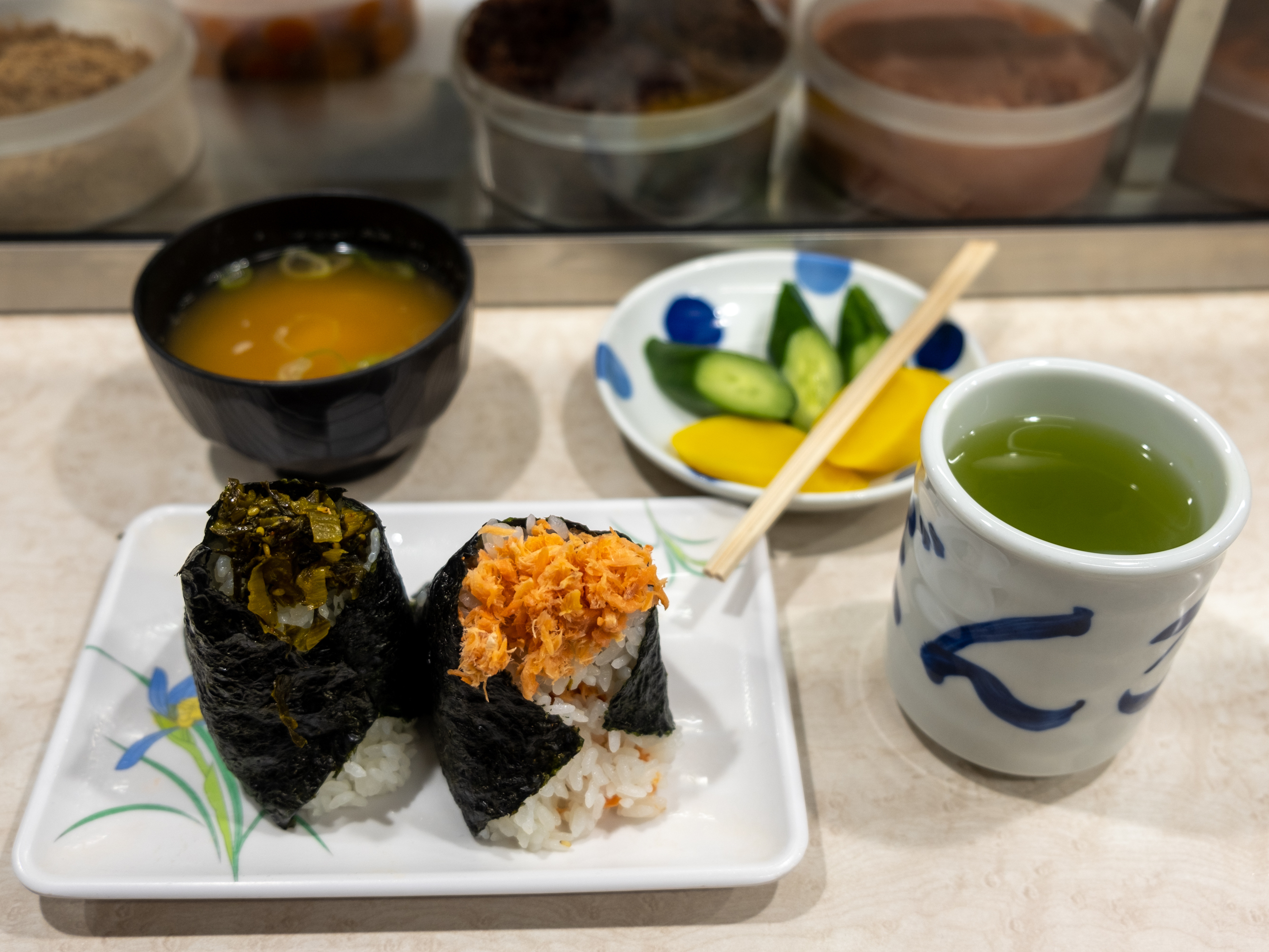caption: A lunch at Onigiri Bongo includes mustard green and salmon flake onigiri, miso soup, pickles and green tea.