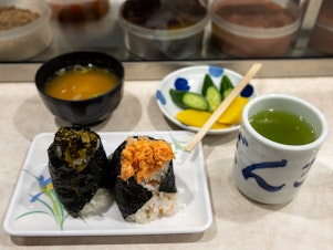caption: A lunch at Onigiri Bongo includes mustard green and salmon flake onigiri, miso soup, pickles and green tea.