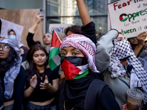 caption: Students from Hunter College chant and hold up signs during a pro-Palestinian demonstration at the entrance of their campus in New York earlier this month.