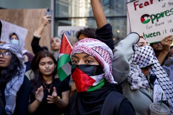 caption: Students from Hunter College chant and hold up signs during a pro-Palestinian demonstration at the entrance of their campus in New York earlier this month.