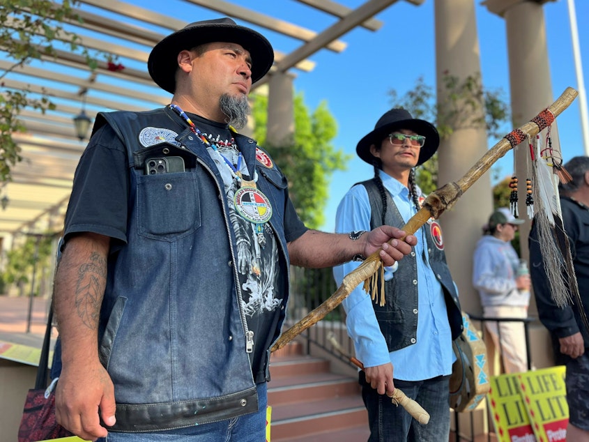 caption: Josh Dini and Gary McKinney protest a planned lithium mine outside a federal appeals court in California in June.