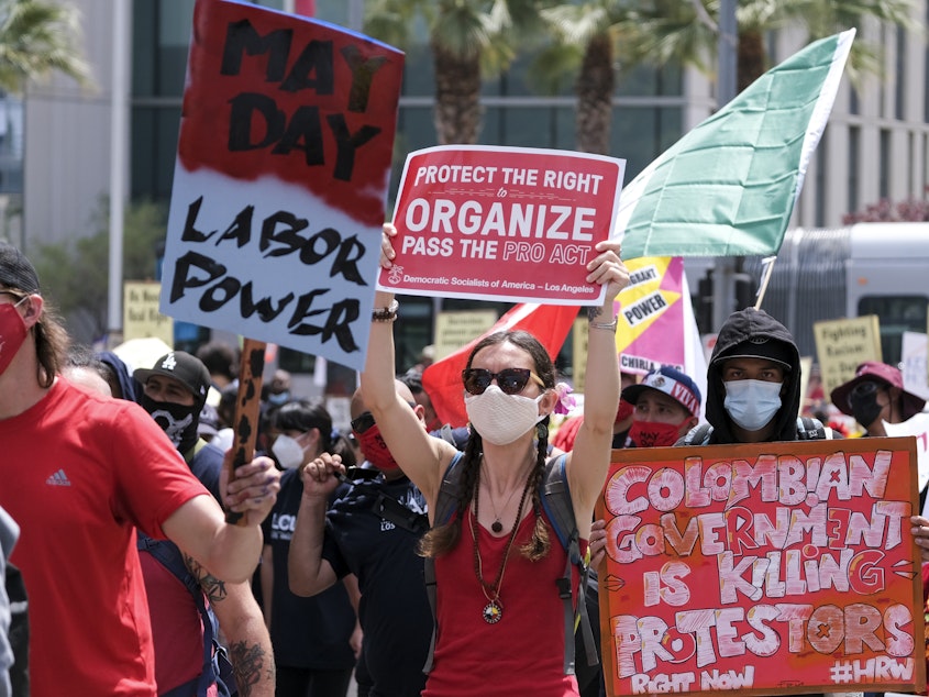 caption: May Day demonstrators march through downtown Los Angeles last year. Thousands of people took to the streets across the nation that May 1 in rallies calling for immigration reform, workers' rights and police accountability.