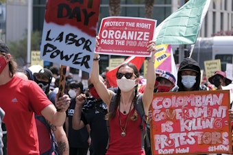 caption: May Day demonstrators march through downtown Los Angeles last year. Thousands of people took to the streets across the nation that May 1 in rallies calling for immigration reform, workers' rights and police accountability.