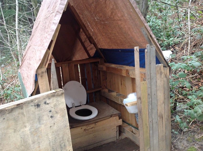 caption: A latrine in the homeless encampment known as the Jungle.
