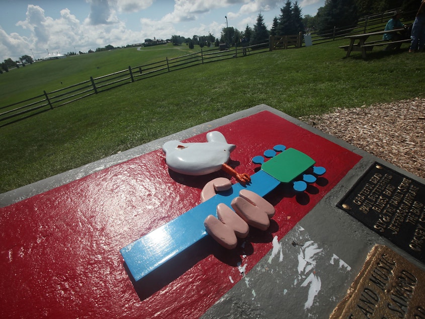 caption: A plaque marks the site of the original Woodstock festival in Bethel, N.Y.