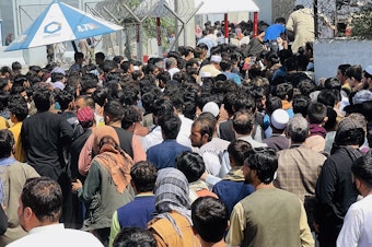 caption: Afghans rush to the Hamid Karzai International Airport as they try to flee the Taliban takeover of Kabul.