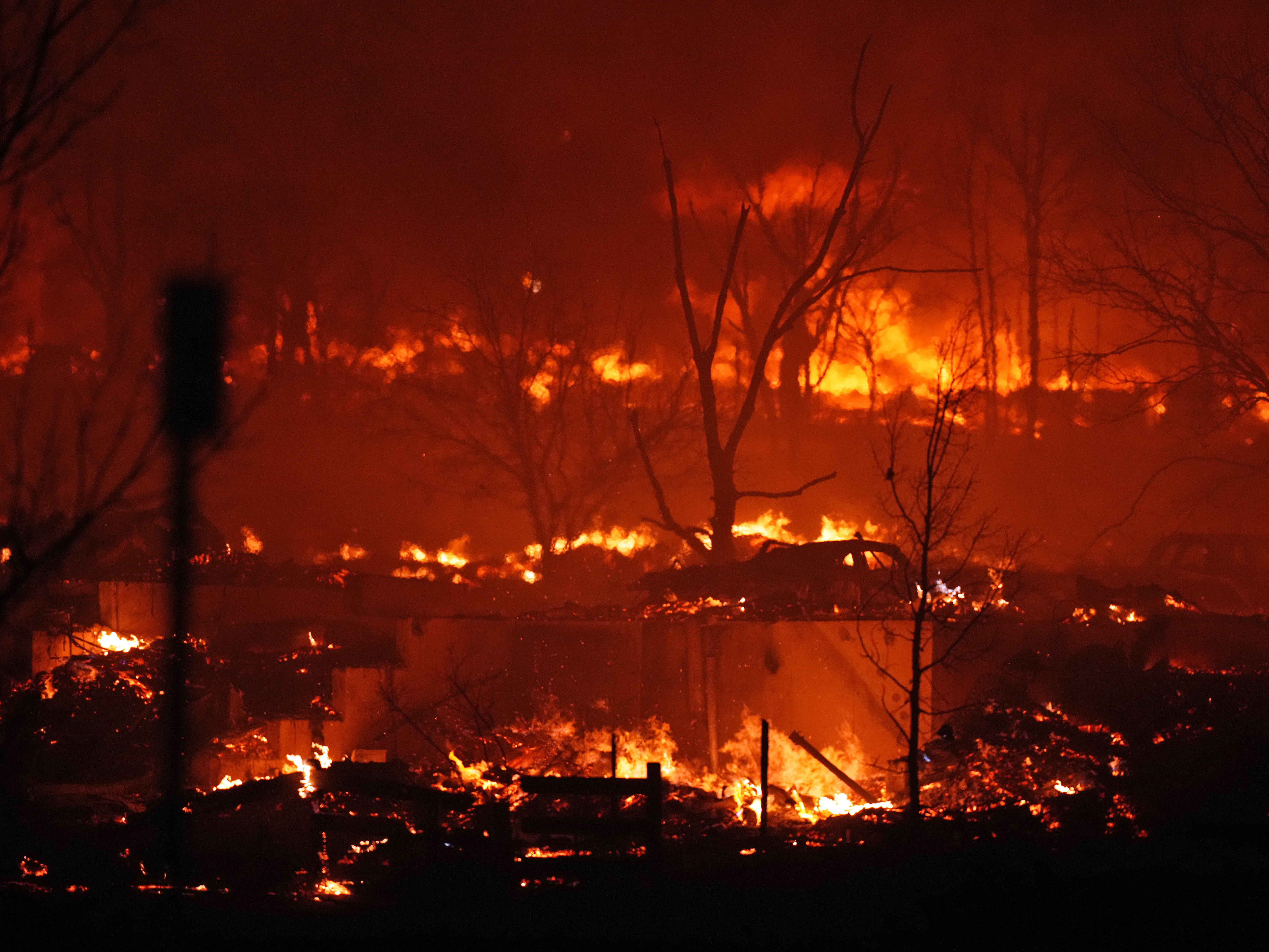 caption: Dec. 30: Broomfield, Co. — Homes burn as a wildfire rips through a development near Rock Creek Village.