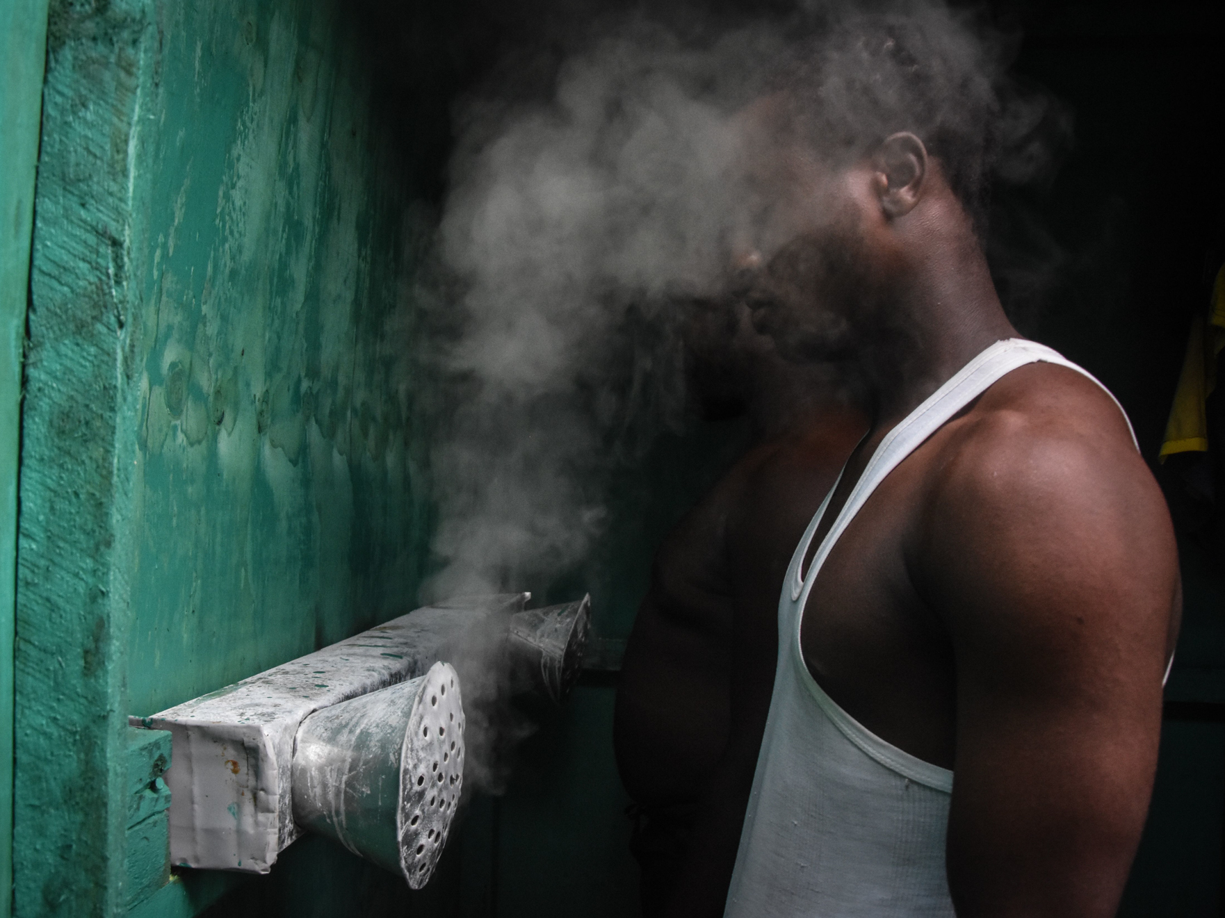 caption: Tanzania is now endorsing COVID-19 vaccines. But for many months, its leaders said that vapors could prevent the disease. Above: A man inhales at a booth installed by an herbalist in Dar es Salaam.
