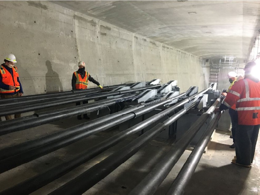 caption: Repair crews examine post-tensioning cables inside the West Seattle Bridge