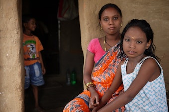 caption: Pujpha Bania, 33, and her daughter Manisha, 8, are migrant workers from Odisha state in northeast India. They travelled several days by train to work at a brick kiln near Hyderabad, India.