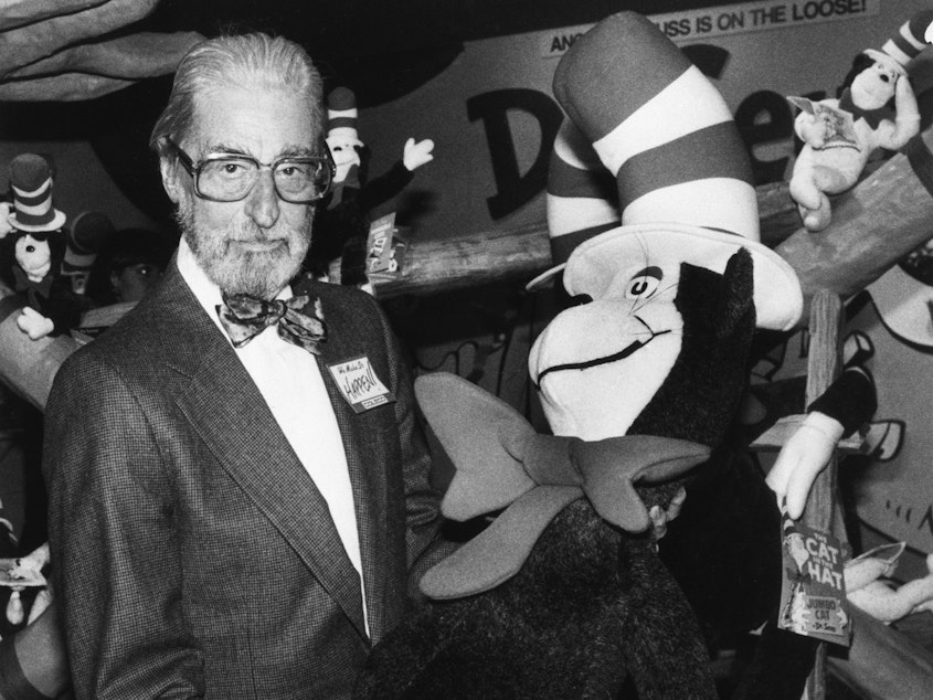 caption: Theodor Geisel — Dr. Seuss --holds a toy of the Cat in the Hat, one of his most famous character creations.