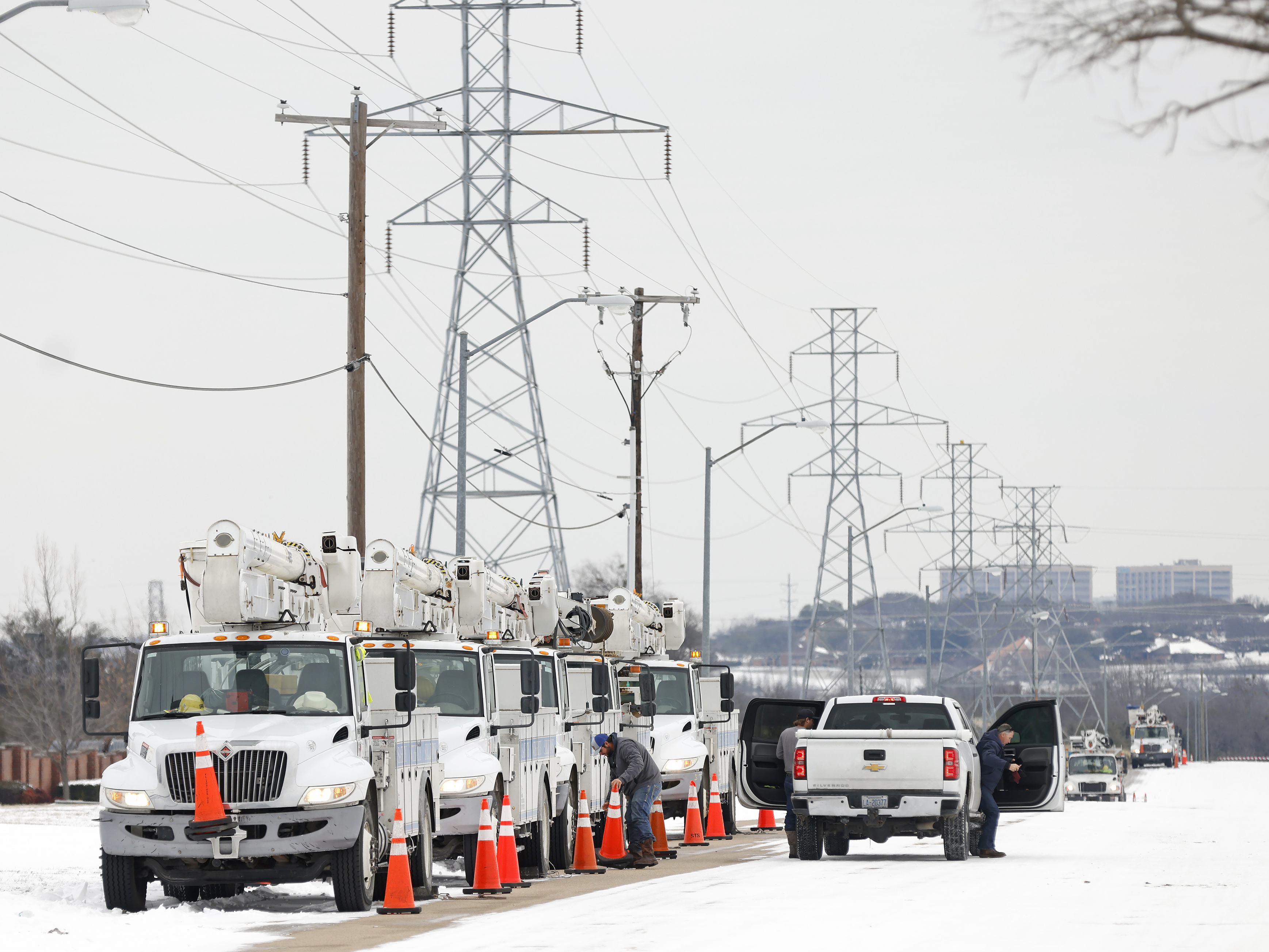 caption: FORT WORTH, TX - FEBRUARY 16: Pike Electric service trucks line up after a snow storm on February 16, 2021 in Fort Worth, Texas. Winter storm Uri has brought historic cold weather and power outages to Texas as storms have swept across 26 states with a mix of freezing temperatures and precipitation. (Photo by Ron Jenkins/Getty Images)