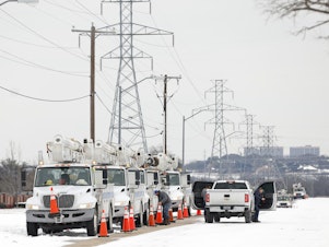 caption: FORT WORTH, TX - FEBRUARY 16: Pike Electric service trucks line up after a snow storm on February 16, 2021 in Fort Worth, Texas. Winter storm Uri has brought historic cold weather and power outages to Texas as storms have swept across 26 states with a mix of freezing temperatures and precipitation. (Photo by Ron Jenkins/Getty Images)