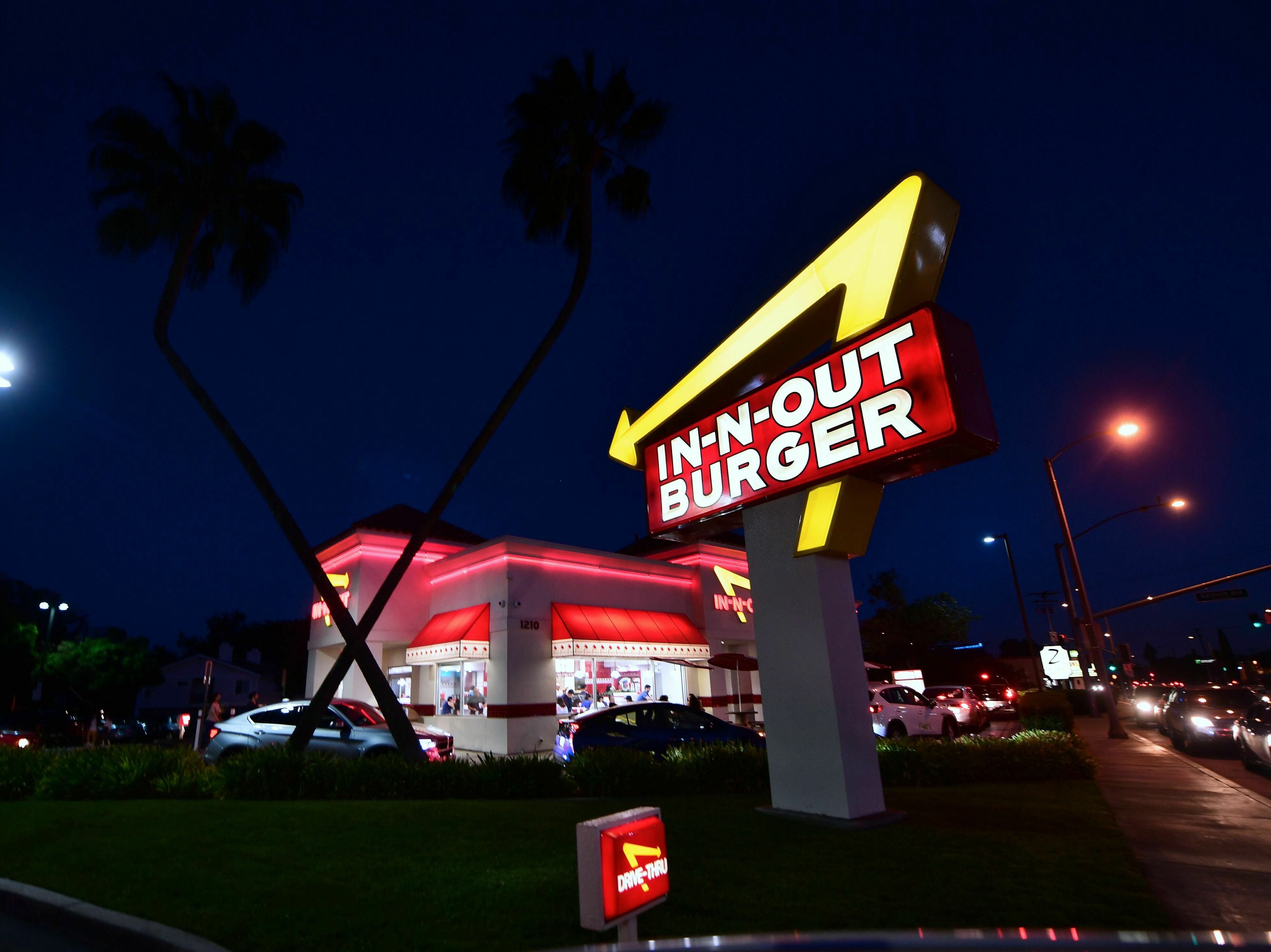 caption: Drivers wait in the drive-thru line at an In-N-Out Burger restaurant in Alhambra, California, on August 30, 2018.