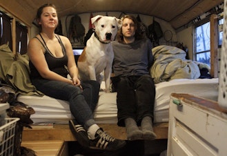 caption: Michelle, 26, and Benjamin, 27, live with their dog, Doogie, on a bus that they park around Seattle. 