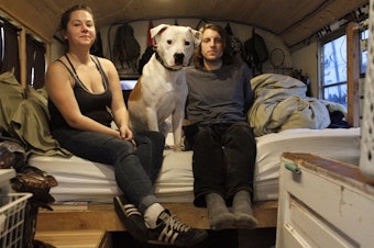 caption: Michelle, 26, and Benjamin, 27, live with their dog, Doogie, on a bus that they park around Seattle. 