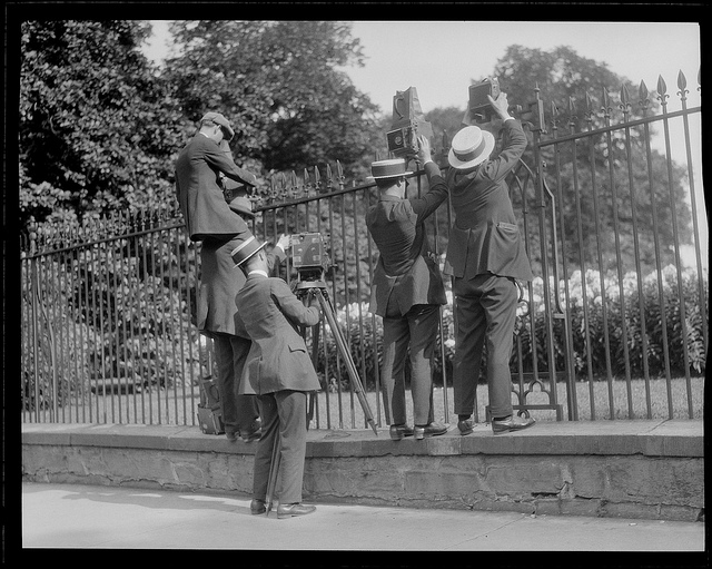 caption: In this archive shot, photographers take pictures over the White House fence when Coolidge died.
