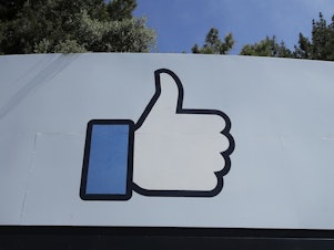 caption: Facebook's thumbs-up "Like" logo is shown on a sign at the company's headquarters in Menlo Park, Calif.