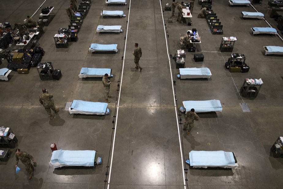 caption: U.S. Army soldiers from the 627th Army Hospital from Fort Carson, Colorado, as well as soldiers from Joint Base Lewis-McChord set up a 250-bed military field hospital for non COVID-19 patients on Tuesday, March 31, 2020, at the CenturyLink Field Event Center in Seattle.