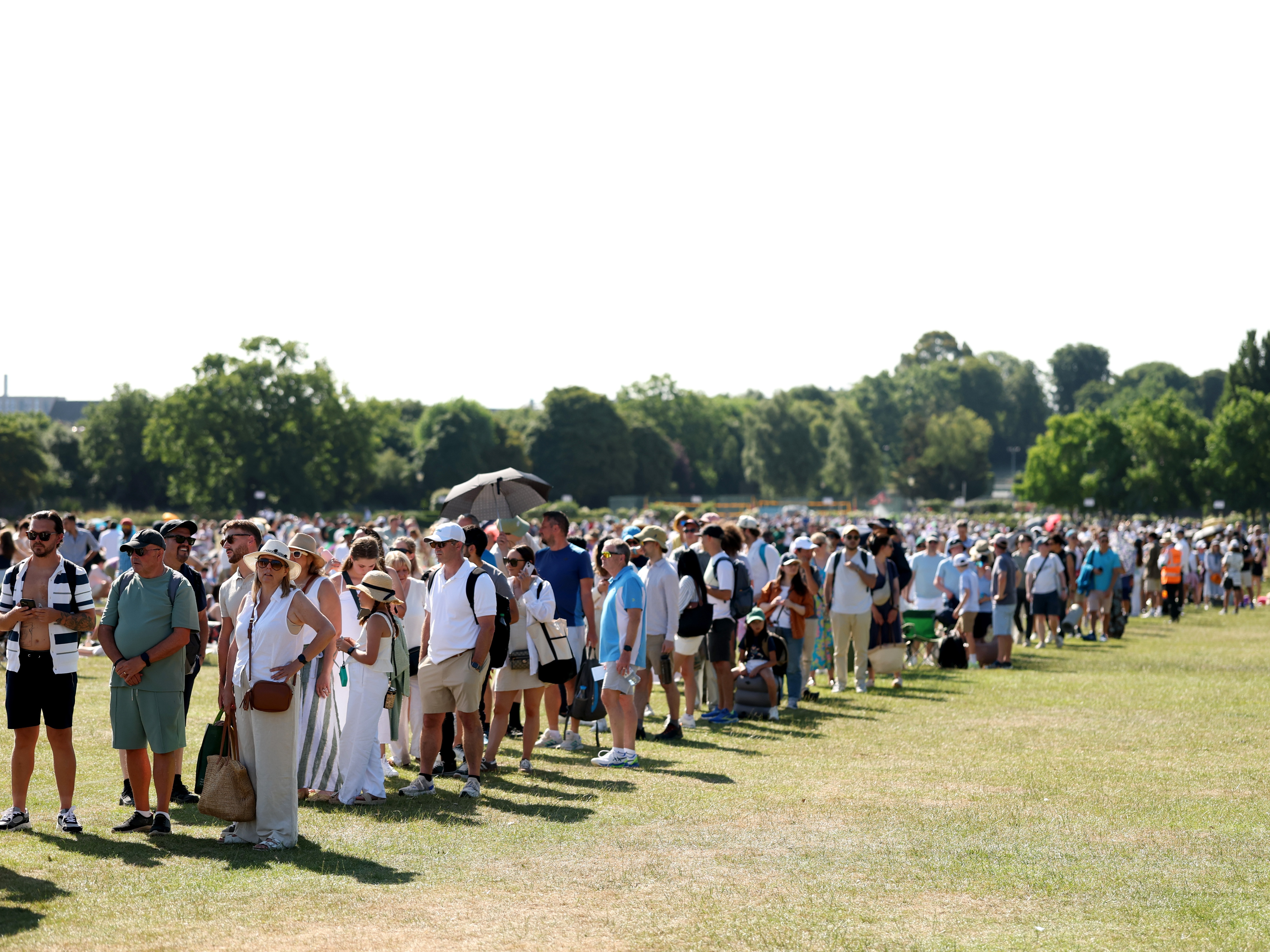 caption: Spectators wait in the Queue on day one of Wimbledon, June 30.