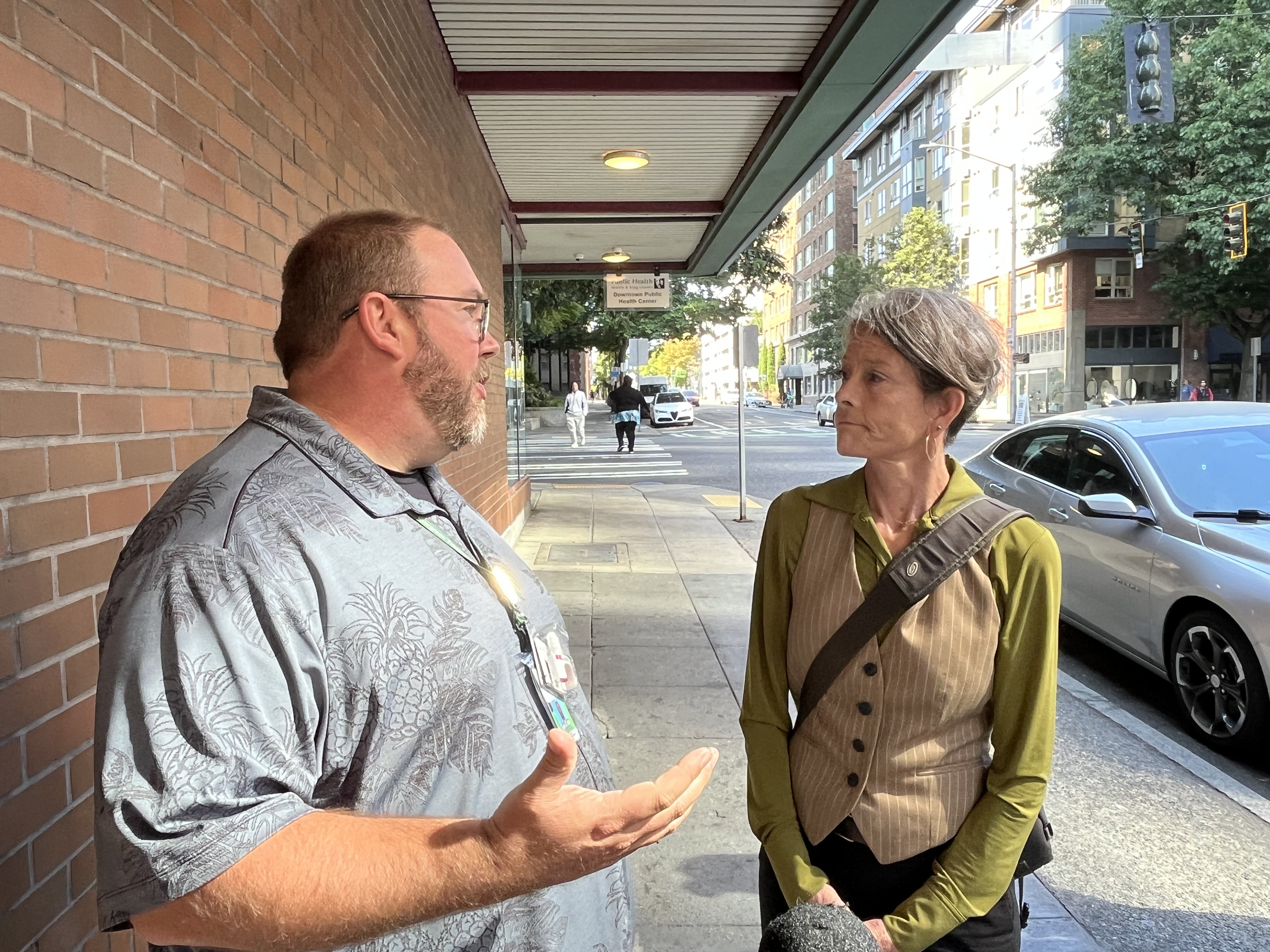 caption: Sean Soth, VP of Clinic Services for Evergreen Treatment Services, shows Seattle City Councilmember Sara Nelson the mobile medication unit in Belltown. 
