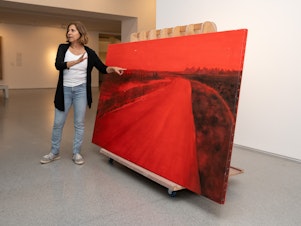 caption: Rescued from her studio in Kibbutz Be'eri near Israel's border with Gaza, artist Ziva Jelin's damaged painting <em>Curving Road </em>is currently on special display in the Israeli Art gallery of the Israel Museum in Jerusalem.