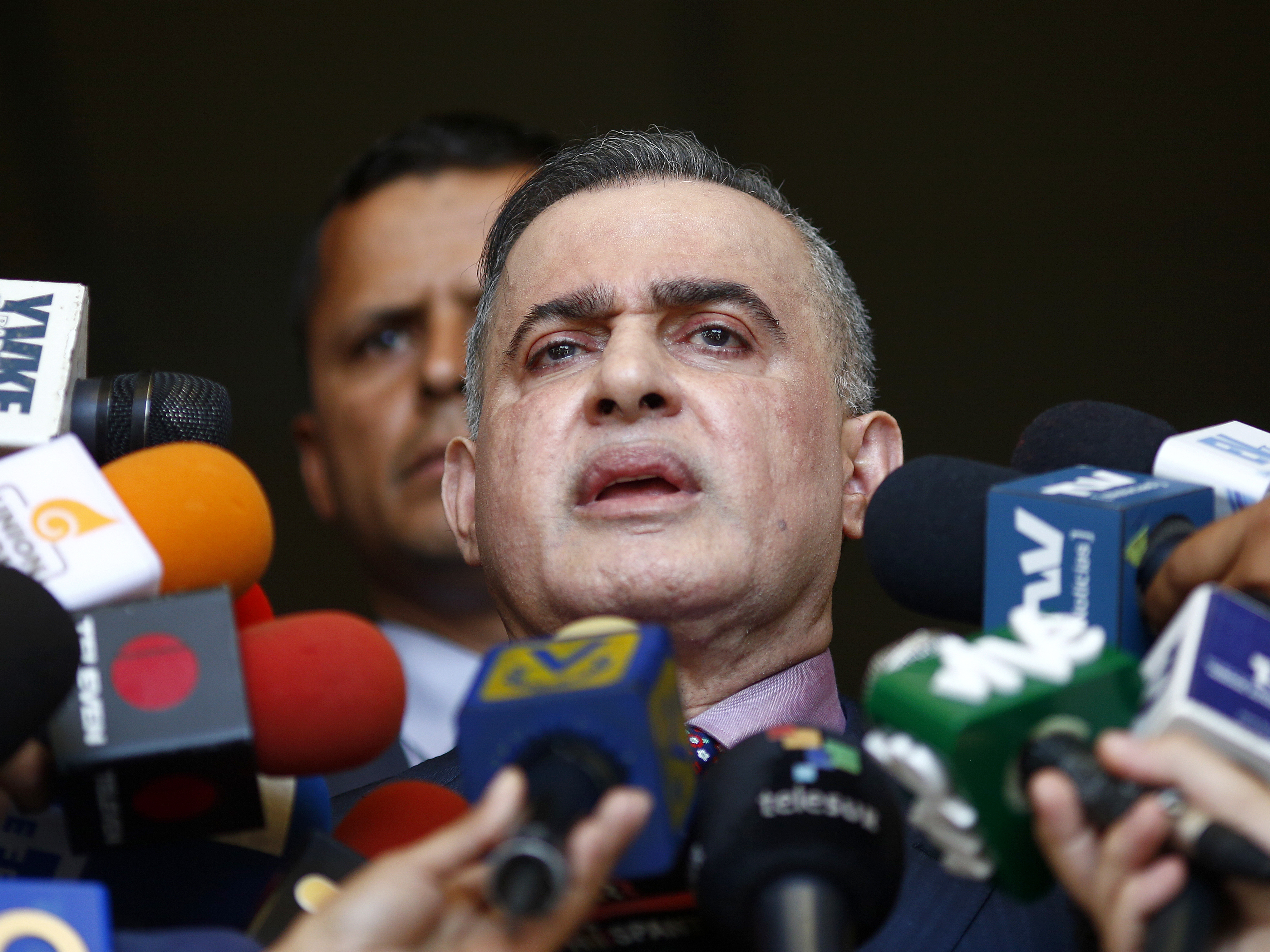 caption: Venezuela's top prosecutor, Tarek William Saab, talks to reporters in Caracas on Tuesday. He announced that Juan Guaidó, now President Nicolás Maduro's most prominent opponent, is barred from leaving the country because of an investigation.
