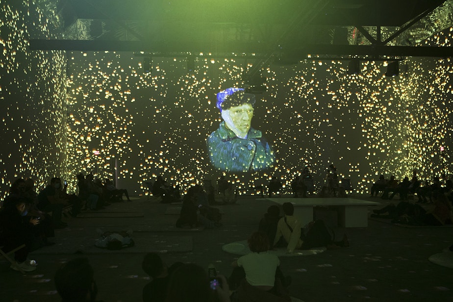 caption: Patrons take in various projections of Van Gogh's work in the 360-degree 8,000 square foot immersive room on Wednesday, October 27, 2021, at the exhibit along Occidental Avenue in Seattle. 
