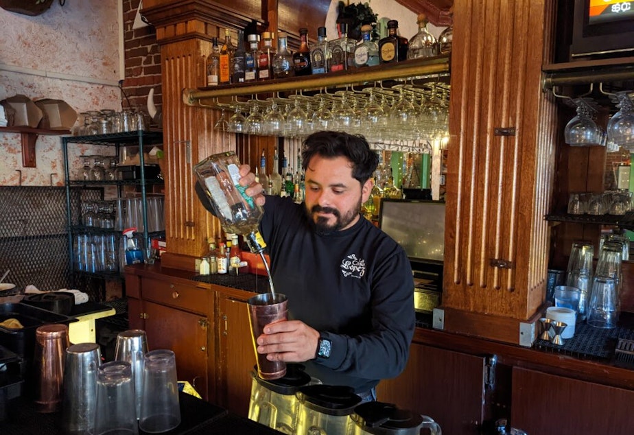 caption: Mitch Lopez pours a drink at the bar of family owned restaurant La Casa Lopez.