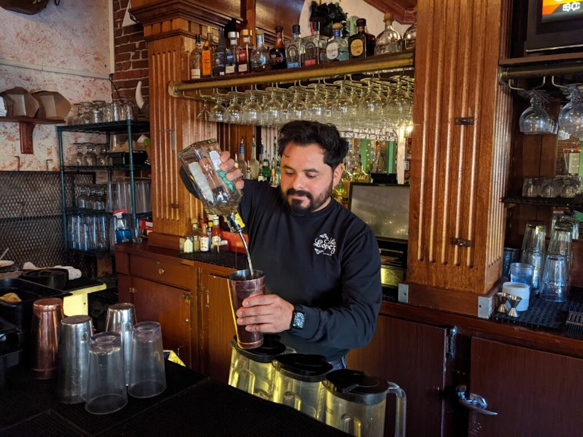 caption: Mitch Lopez pours a drink at the bar of family owned restaurant La Casa Lopez.