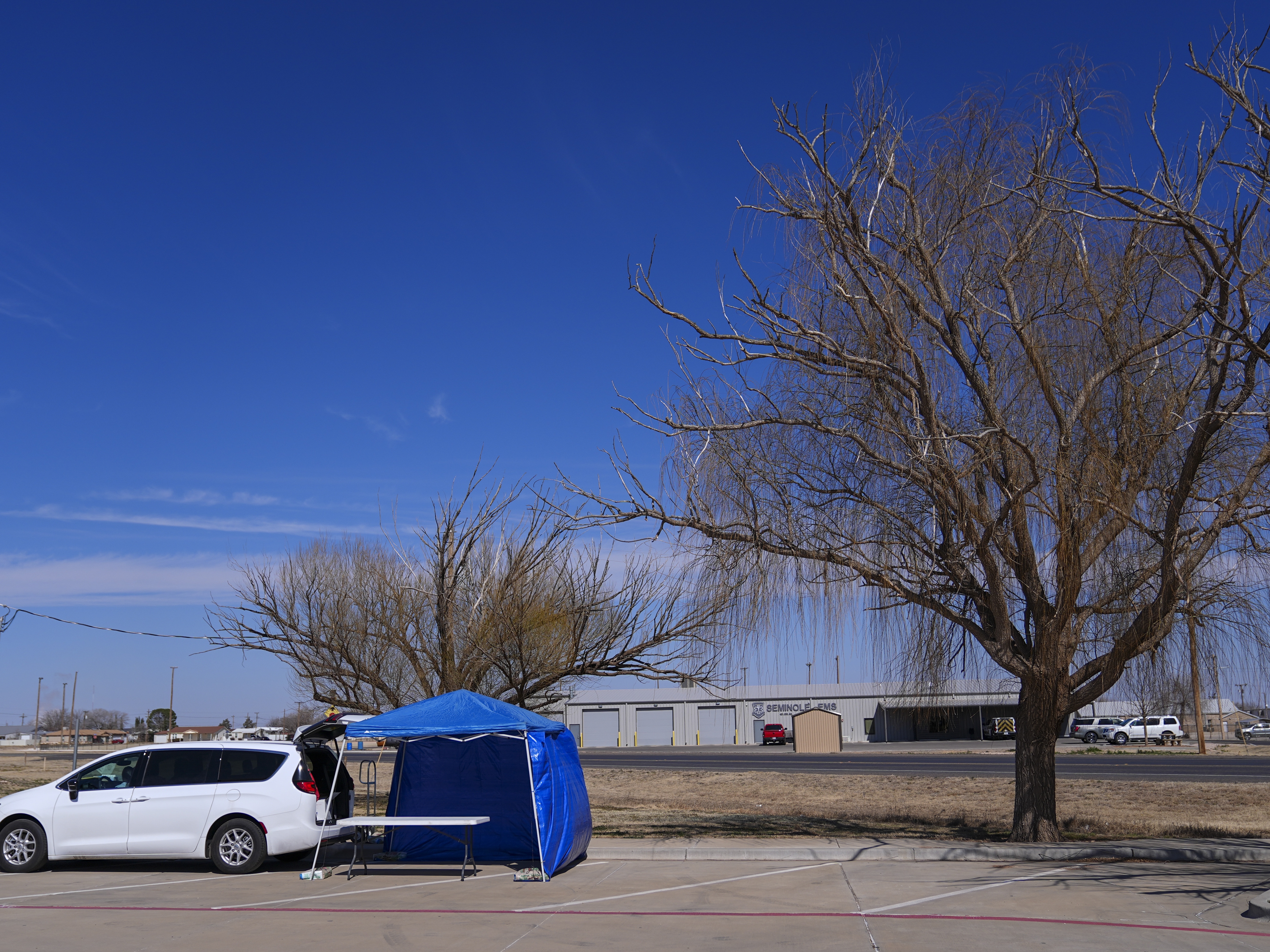 caption: A van is seen at the site of a measles testing location in the parking lot of Seminole Hospital District on Feb. 21 in Seminole, Texas.