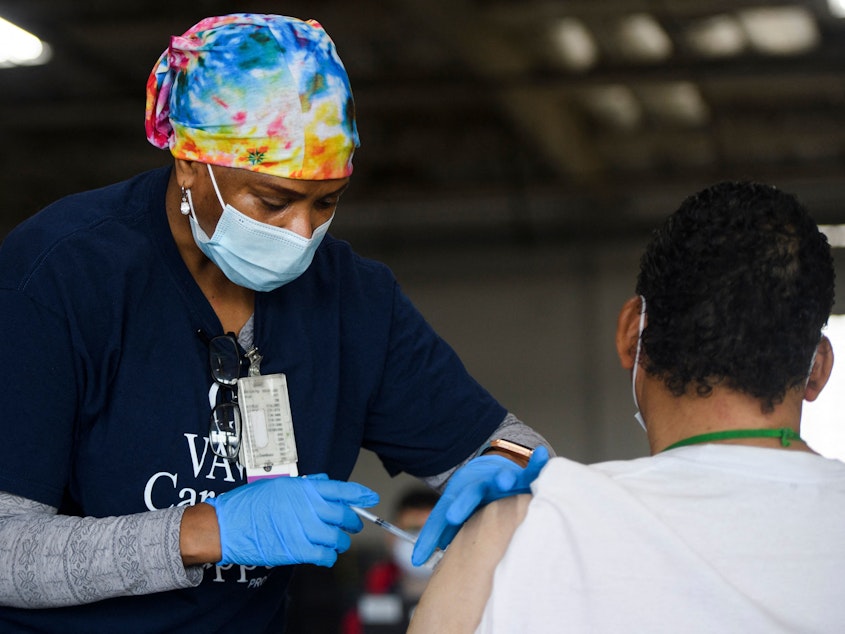 caption: A nurse administers the Moderna COVID-19 vaccine at a Veterans Administration Long Beach Healthcare System pop-up vaccination site at the Dae Hueng Presbyterian Church on Saturday in Gardena, Calif. More than half of U.S. adults have now received at least one vaccine dose.